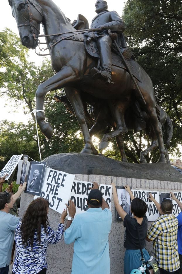 Dallas activists tied pictures of abolitionists to the statue of Robert E. Lee at Lee Park...