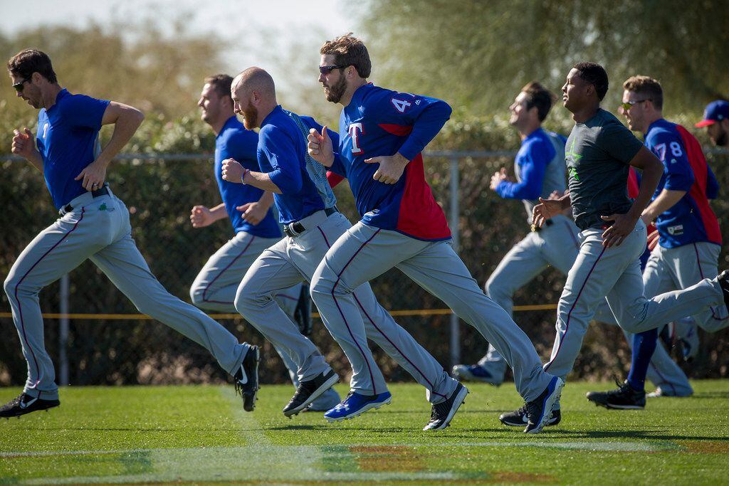 Texas Rangers pitcher Clayton Blackburn (47) runs with teammates during a spring training...