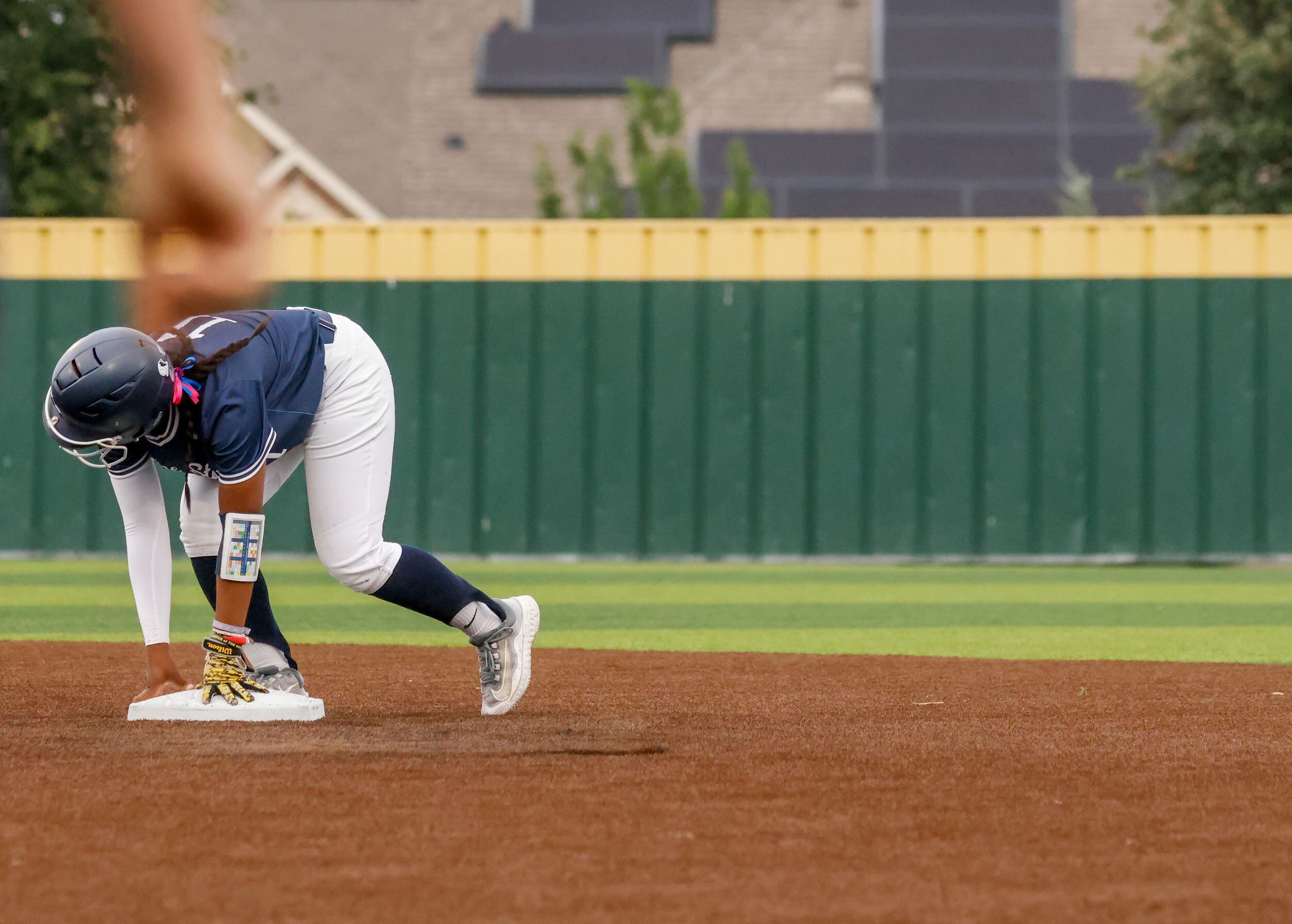 Frisco Lone Star center fielder Kirstyn Jones (11) uses their hands to get to an upright...