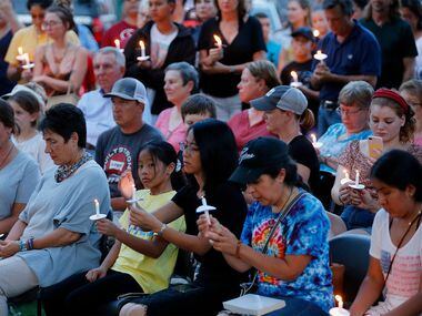 Area residents gather for a candle light vigil held at Dr. Glenn Mitchell Memorial Park in...
