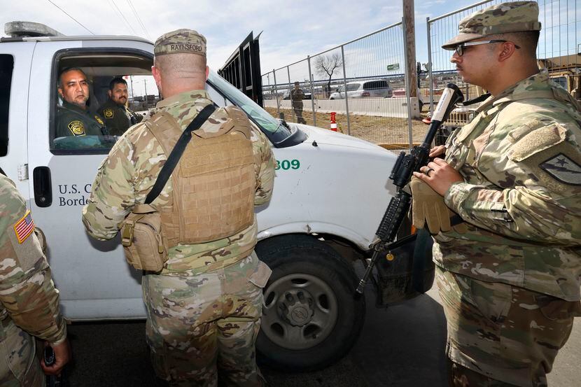 Texas National Guard soldiers talk with Border Patrol agents in front of the gate at Shelby...