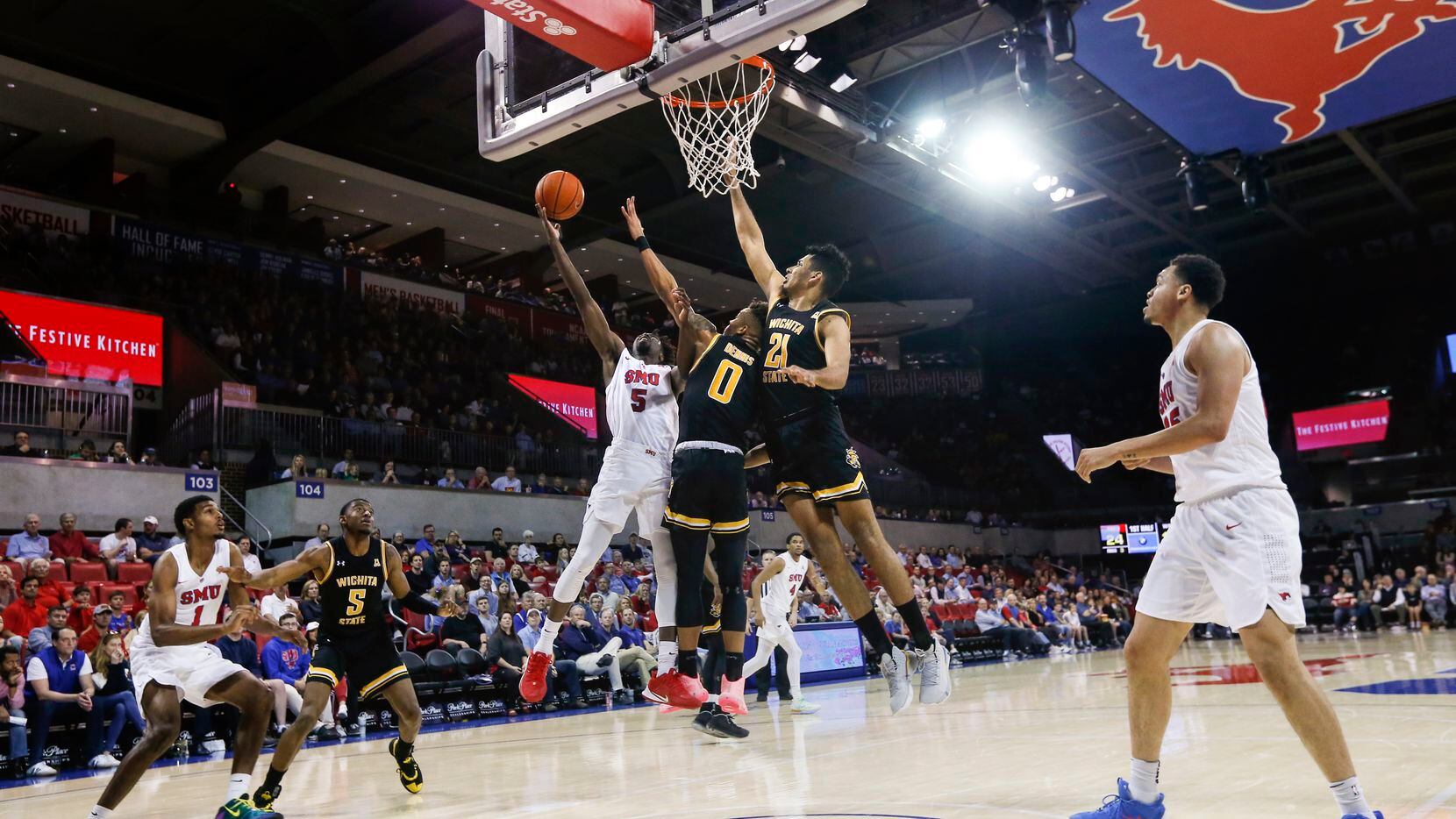 Southern Methodist Mustangs guard Emmanuel Bandoumel (5) goes up for a shot past Wichita State Shockers guard Dexter Dennis (0) and center Jaime Echenique (21) during the first half of am NCAA men's basketball matchup between SMU and Wichita State on Sunday, March 1, 2020 at Moody Coliseum in University Park, Texas.