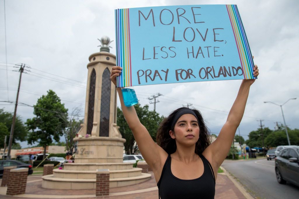 Raquel Flores, of Richardson, Texas holds up a sign at the Legacy of Love Monument on June...