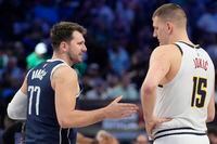 Dallas Mavericks guard Luka Doncic (77) offers his hand to shake with Denver Nuggets center...