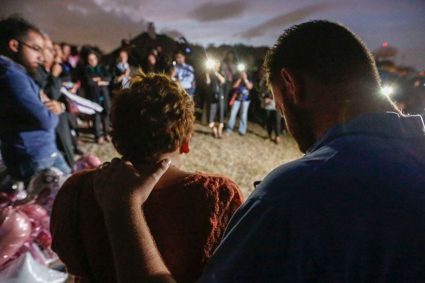 Nicole and Scott Snyder bow their heads in prayer at a vigil for Sherin Mathews in...