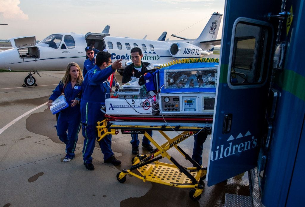 Paramedics transport one of ten babies in a Neonatal Intensive Care Unit from a Cook...