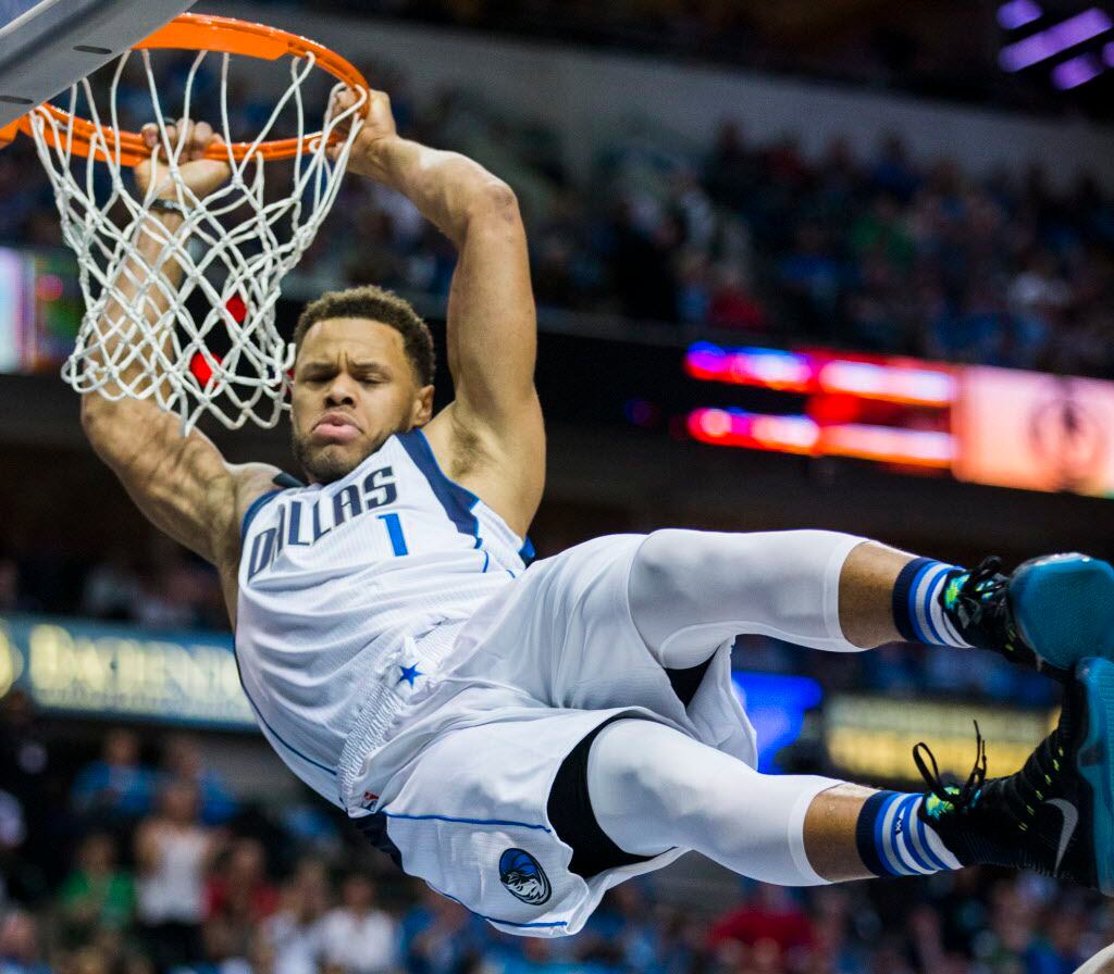 Dallas Mavericks guard Justin Anderson (1) hangs on the rim after dunking the ball during...