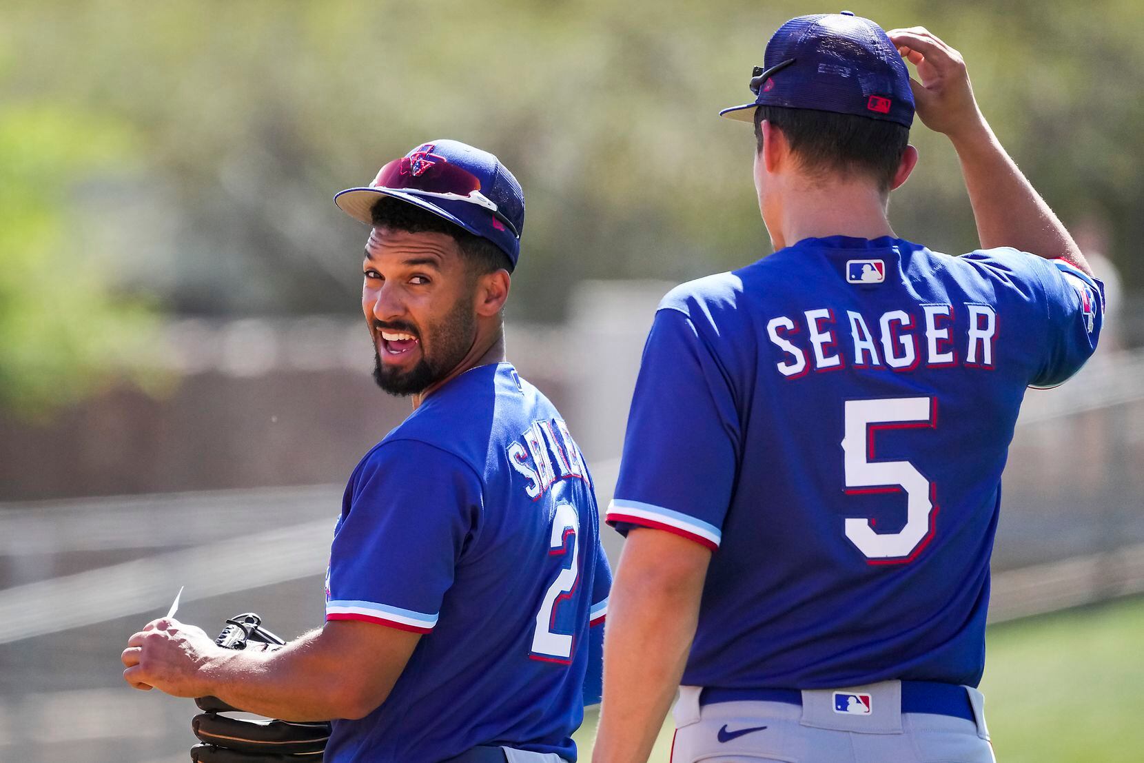 Texas Rangers second baseman Marcus Semien talks with shortstop Corey Seager as they take...