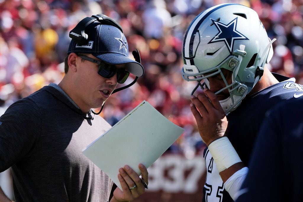 FILE - Dallas Cowboys offensive coordinator Kellen Moore (left) and quarterback Dak Prescott (right) talk during a time out during an NFL football game against Washington Redskins, Sunday, Sept. 15, 2019, in Landover, Md. (AP Photo/Mark Tenally)