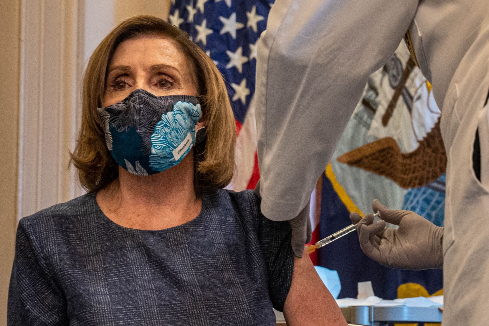 House Speaker Nancy Pelosi receives a COVID-19 vaccination shot from Dr. Brian Monahan,...