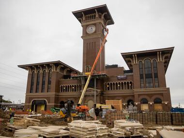 A crew from MEI Rigging & Crating works to install a 12-foot glass clock on the Grapevine...