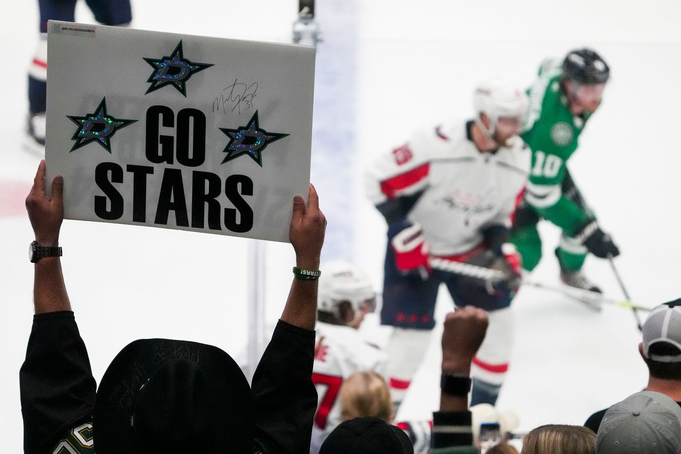 Dallas Stars fans cheer their team during the third period of a victory over the Washington...