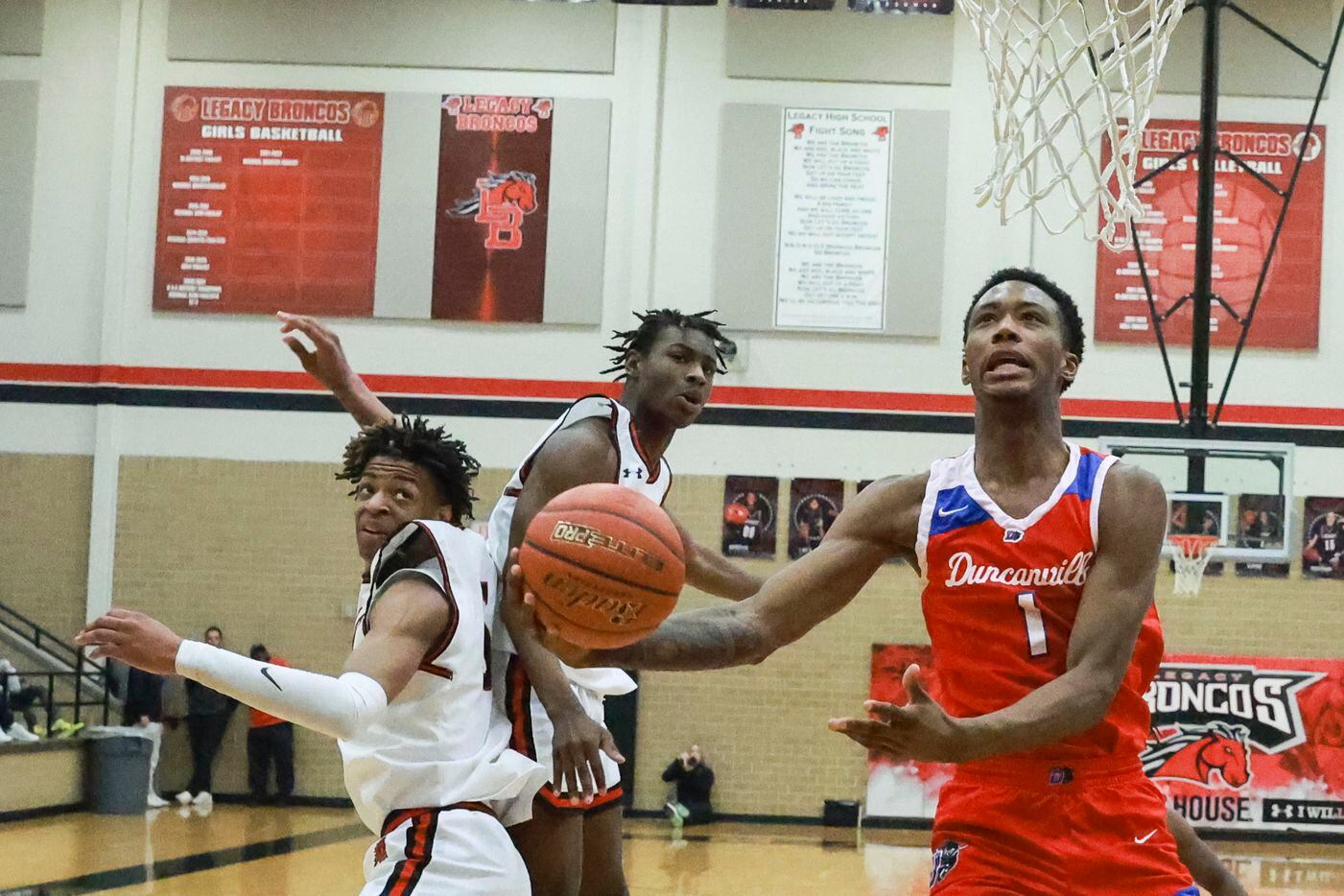 Duncanville High School’s Ron Holland (1) jumps past  Mansfield Legacy High School’s Ahmare...