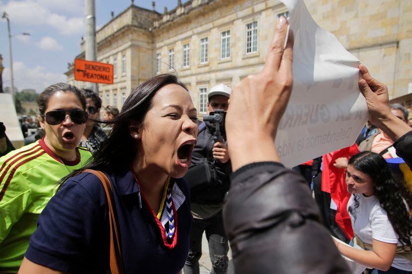 Una mujer venezolana reacciona contra activistas que se oponen a la intervención extranjera...