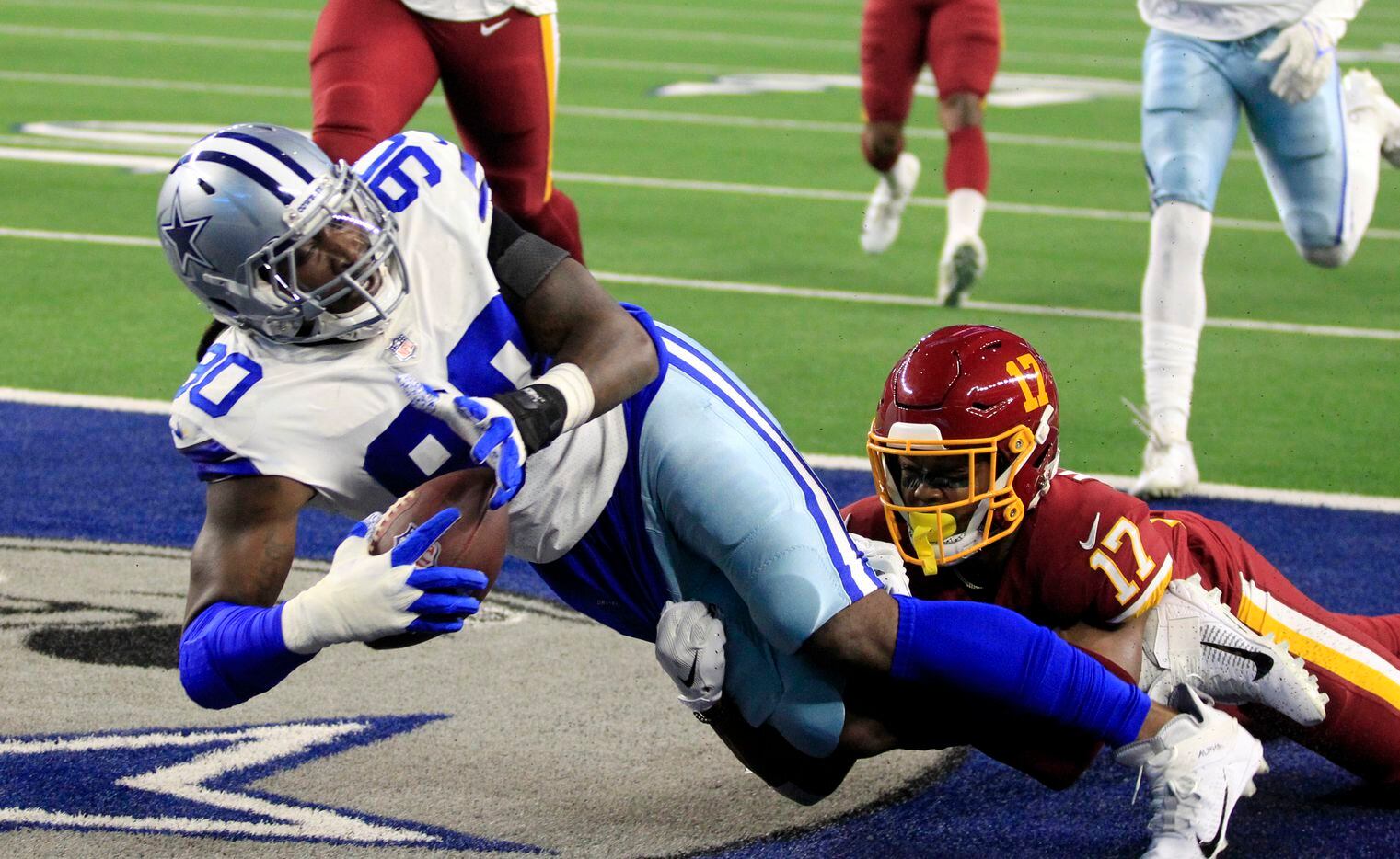 Dallas Cowboys defensive end Demarcus Lawrence (90) falls into the end zone for a touchdown, as Washington Football Team wide receiver Terry McLaurin (17) arrives late during the first half of a NFL football game at AT&T Stadium in Arlington, TX on Sunday, December 26, 2021.