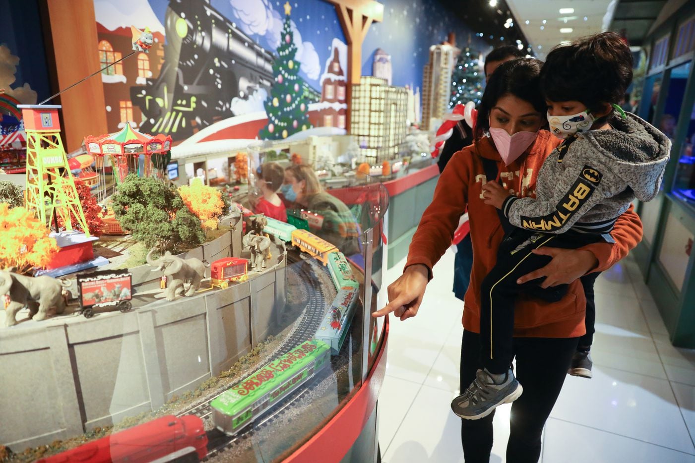 Piyusha Patel and Dax Patel take a look at "The Trains at NorthPark," one of NorthPark Center's holiday hallmarks, which also include Candy Santa and his reindeer made from pecans and shows by Scrooge Puppet Theatre and the Twelve Days of Christmas Clock.
