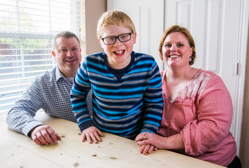 Ben Schneider, 11, poses for a portrait with his parents, Rob and Jenn Schneider, on...
