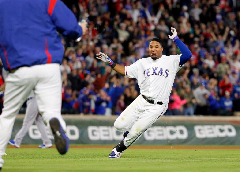 Texas Rangers' Elvis Andrus runs through the infield trying to avoid the celebration with...