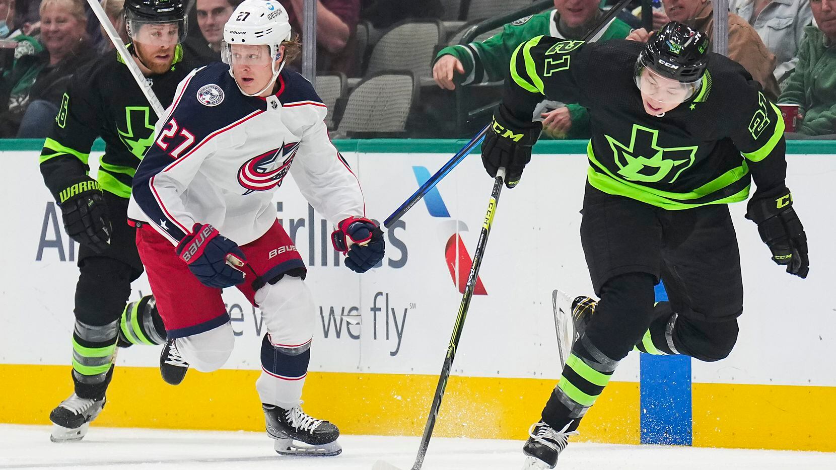 Dallas Stars left wing Jason Robertson (21) brings the puck up the ice past Columbus Blue Jackets defenseman Adam Boqvist (27) during the first period of an NHL hockey game at the American Airlines Center on Thursday, Dec. 2, 2021, in Dallas.