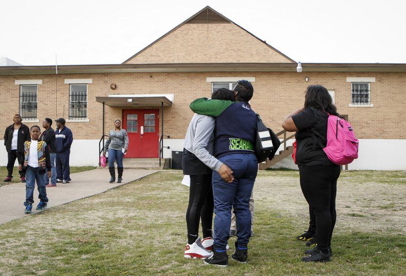 Parent Catrina Henderson (center, in blue shirt), comforts a distraught student at the...