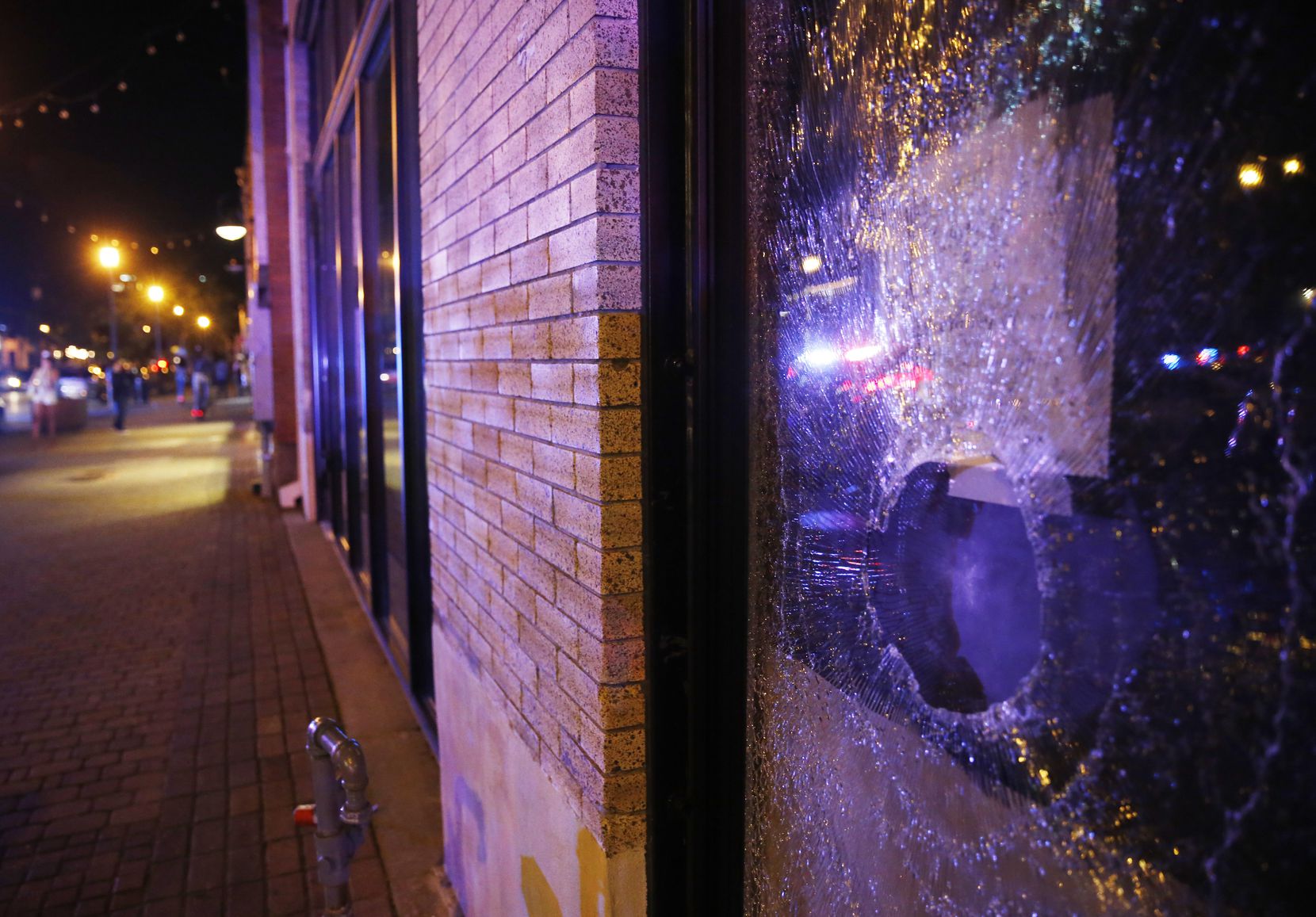 Busted window of a business along Main Street in Deep Ellum in downtown Dallas, on Friday,...
