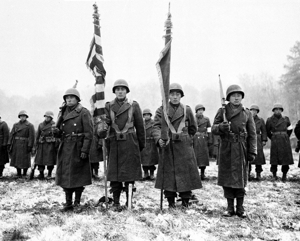 Two color guards and color bearers of the Japanese-American 442nd Combat team stand at...