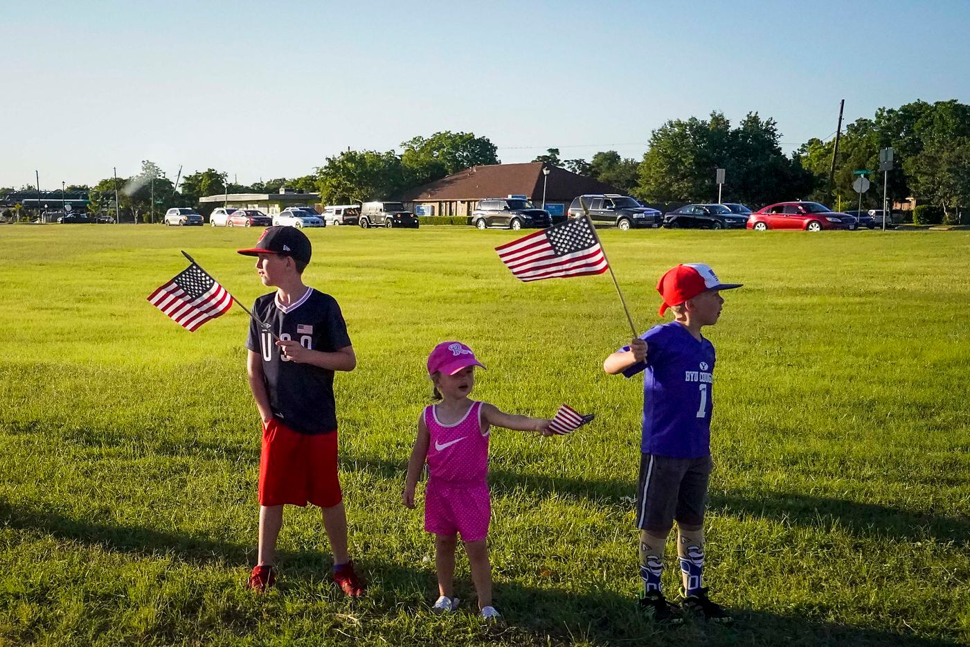 A group of children wave flags along Mockingbird Lane as President Donald TrumpÕs motorcade approaches Dallas Love Field after a private fundraiser on Thursday, June 11, 2020, in Dallas. (Smiley N. Pool/The Dallas Morning News)