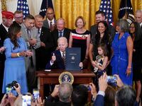 President Joe Biden holds the "PACT Act of 2022" after signing it during a ceremony in the...