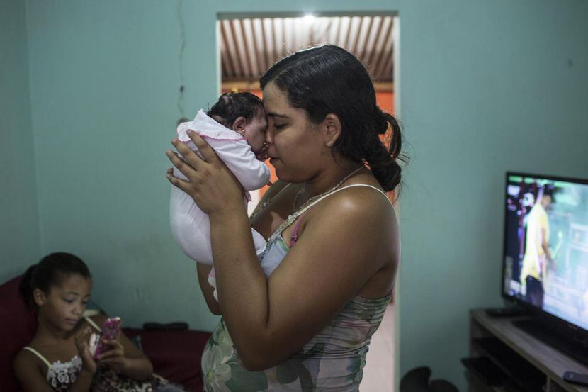 Cleane Serpa, de 18 años, carga a su prima recién nacida, quien nació con microcefalia,...