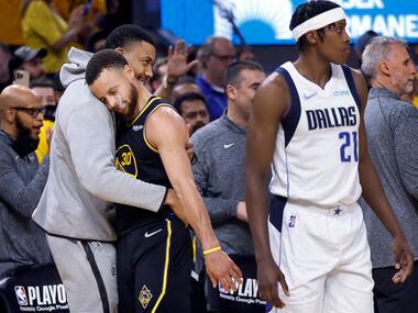 Golden State Warriors guard Stephen Curry (30) receives a hug from a teammate as he comes...