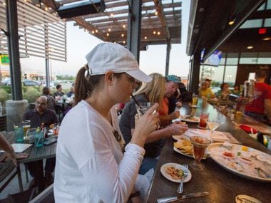 Dana Eldridge, center, takes a sip of her drink at the peninsula bar Fish City Grill in...