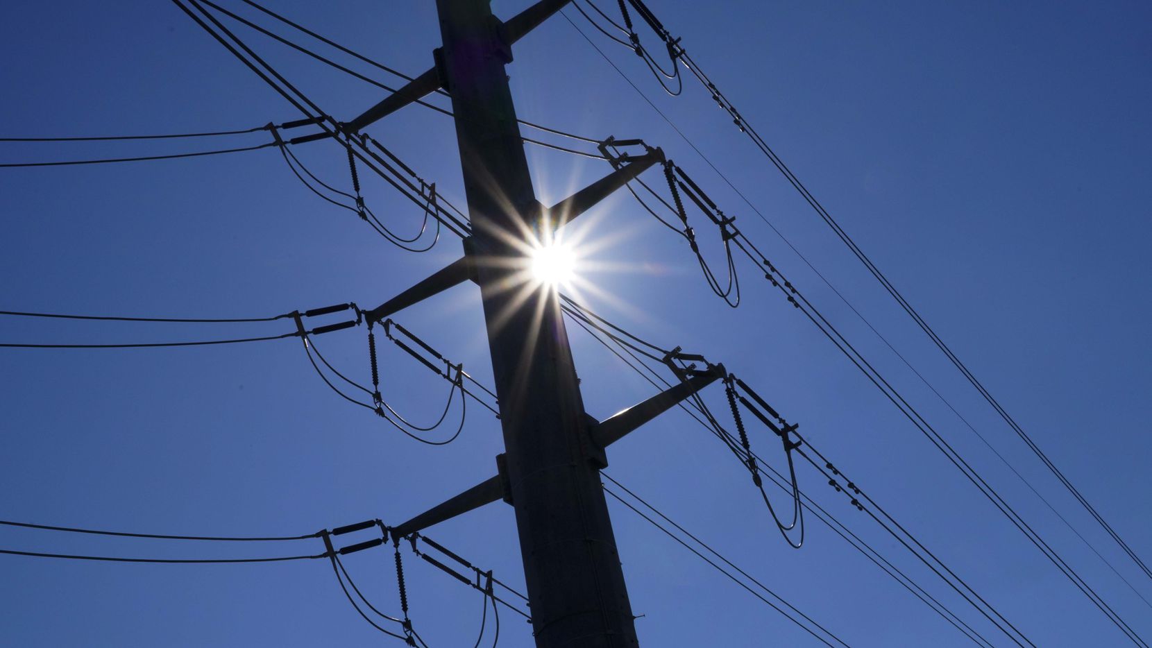 Blue skies and sunshine are seen behind Oncor electric transmission lines in Dallas. ...