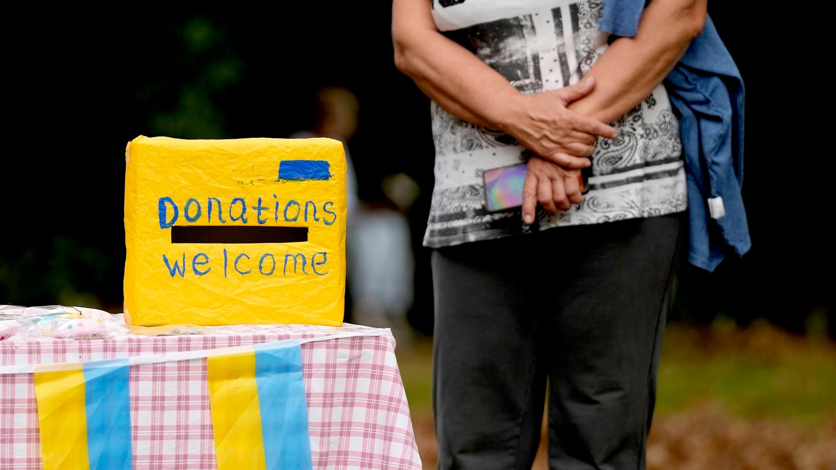 A woman waits near a donation box at the celebration for the Ukraine Independence day at a...