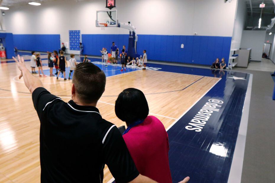 Ben Hunt, left, Camps & Community Basketball Manager shows Dallas Mavericks interim CEO Cynt...