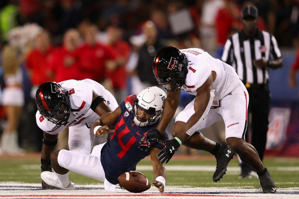 TUCSON, ARIZONA - SEPTEMBER 14:  Quarterback Khalil Tate #14 of the Arizona Wildcats fumbles the football as linebackers Riko Jeffers #6 and Jordyn Brooks #1 of the Texas Tech Red Raiders recover during the first half of the NCAAF game at Arizona Stadium on September 14, 2019 in Tucson, Arizona.