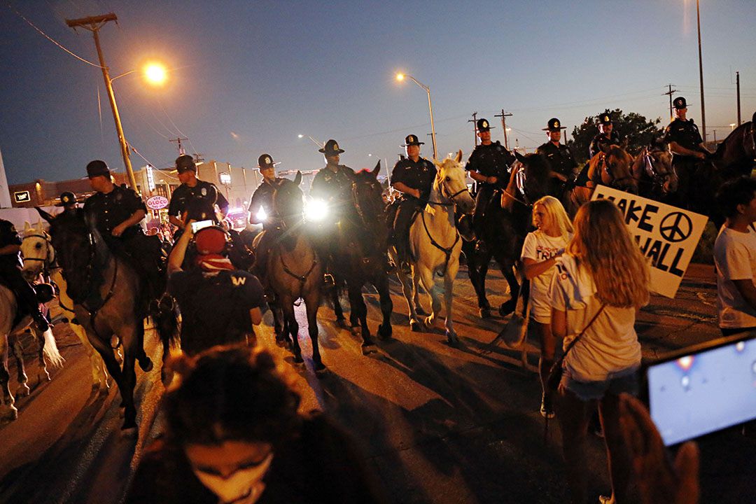  Mounted Dallas Police Department officers move protestors down Cadiz Street following a...