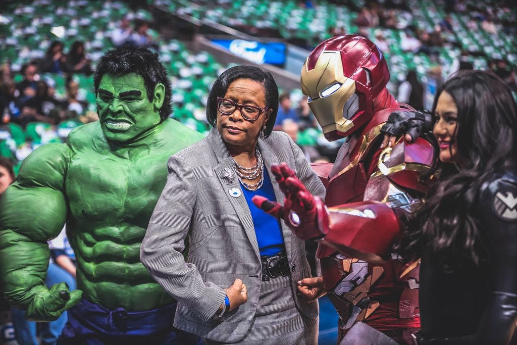 Mavericks CEO Cynt Marshall is flanked by the Incredible Hulk, Iron Man and the Black Widow at a Mavs game.