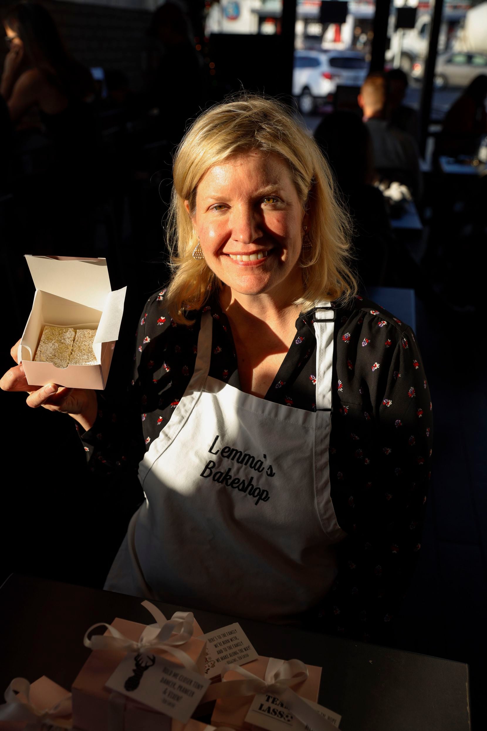 Cathy McEachern poses with some of her pink boxes containing her version of Ted Lasso's biscuits — hot sellers to fans of Apple TV's hit series. Some customers meet her at  White Rock Coffee on Royal Lane to pick up their orders. She's looking for space to open her own bakery next year.