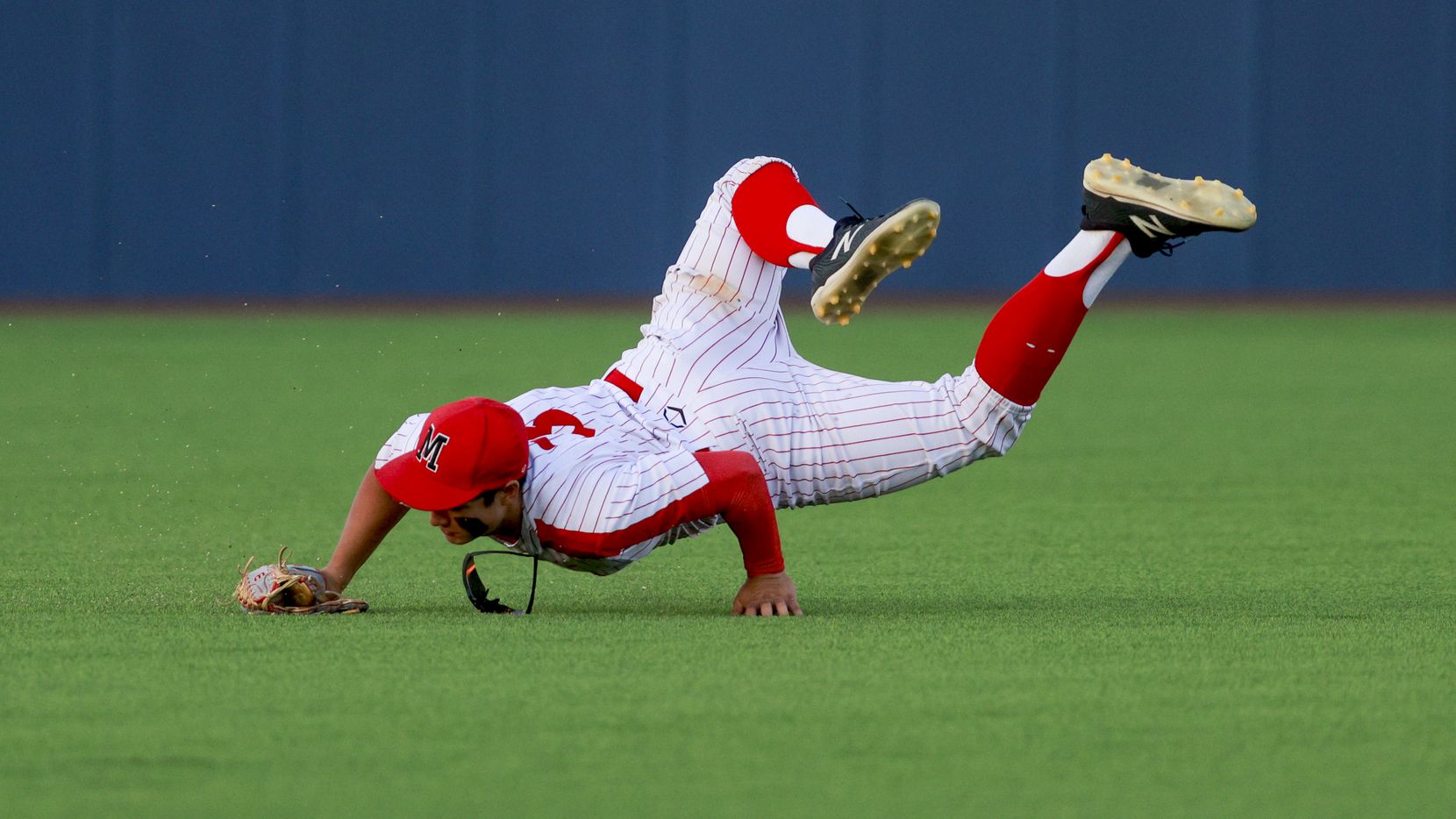 Flower Mound Marcus center fielder Jake Duer (3) makes a diving catch for an out during game...