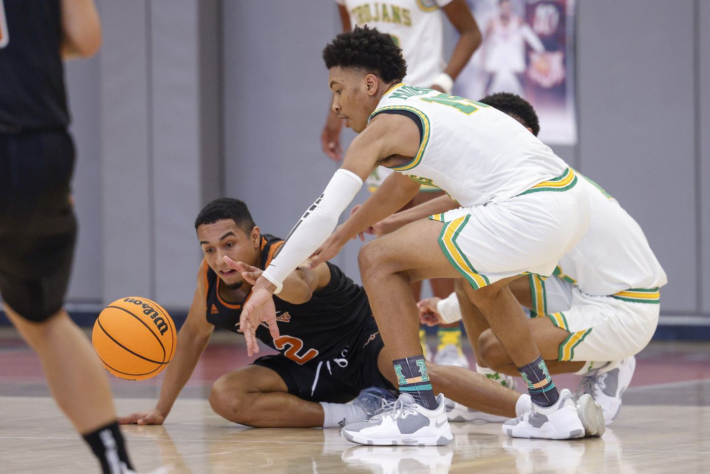 W.T. White guard Raul Nieves (2) and Madison forward Latrelle Wright (15) reach for a loose ball during the third quarter of a Dallas ISD Holiday Invitational basketball tournament game at Woodrow Wilson High School in Dallas, Tuesday, Dec. 28, 2021.