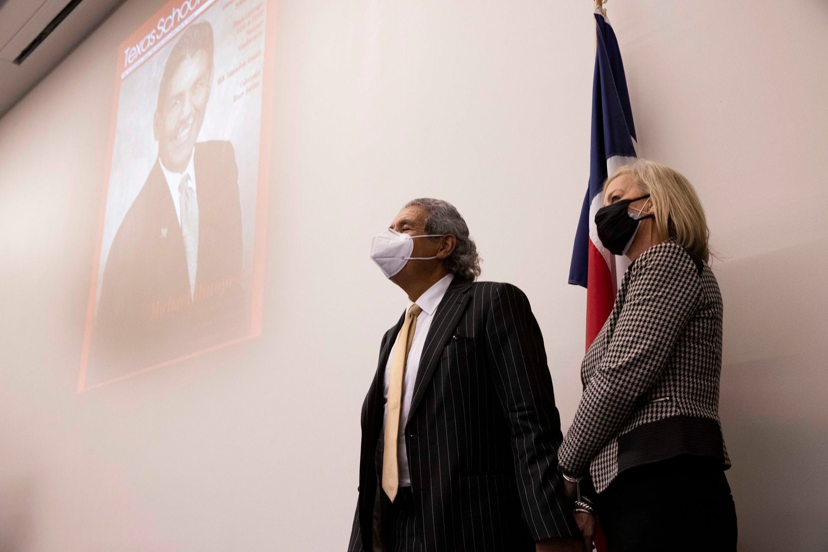 Dallas ISD superintendent Michael Hinojosa (left) holds his wife Kitty's hand as they watch a slideshow of his life during a press conference announcing he will be leaving DISD by the end of the year.