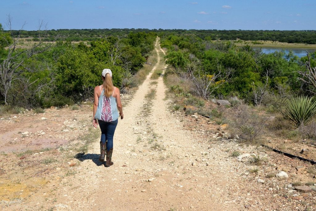 Amy Greer walks along the property line of her cattle ranch in Brady, Texas. Her family is...