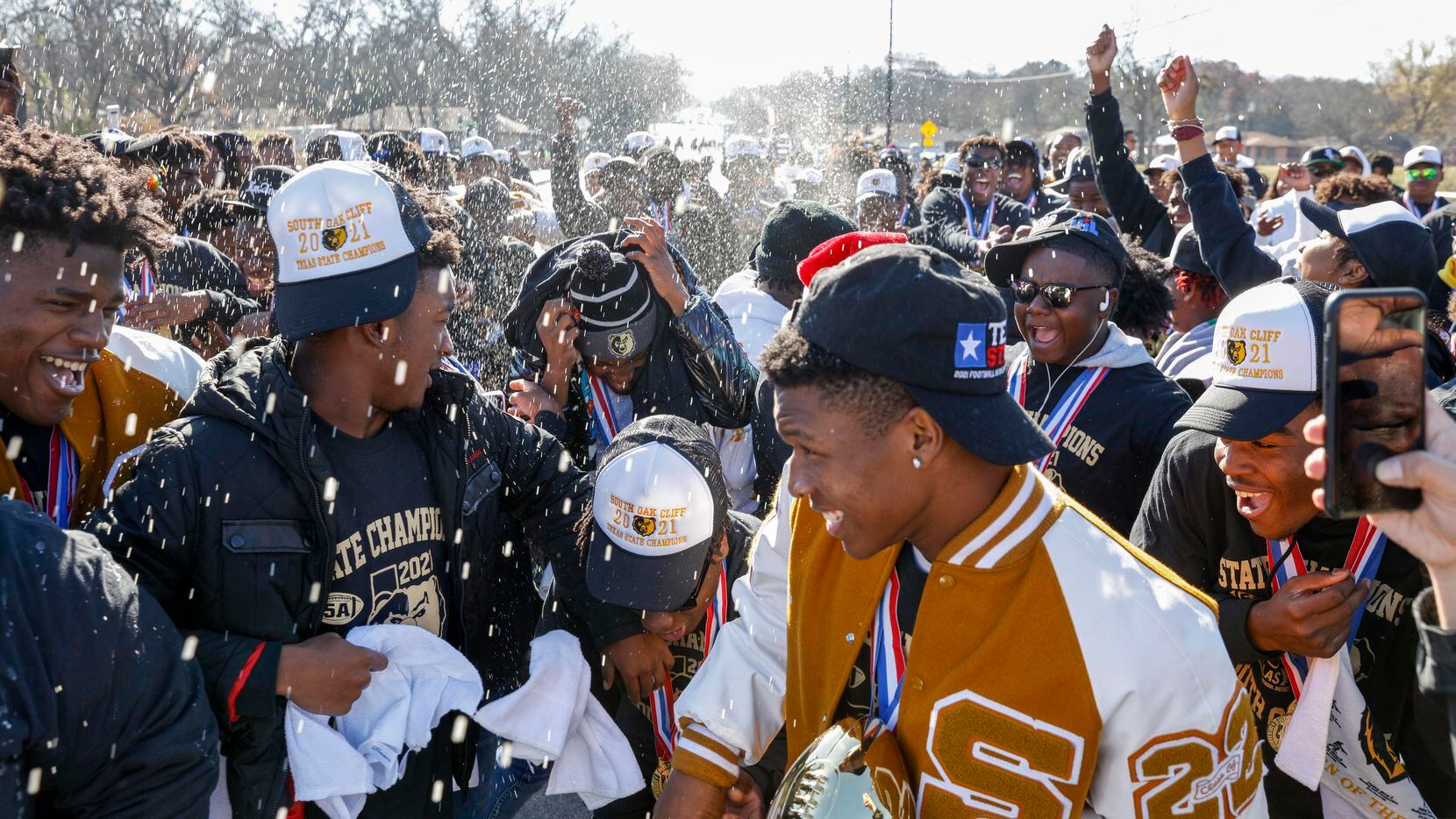 Water is sprayed as members of the South Oak Cliff team celebrate during a parade...