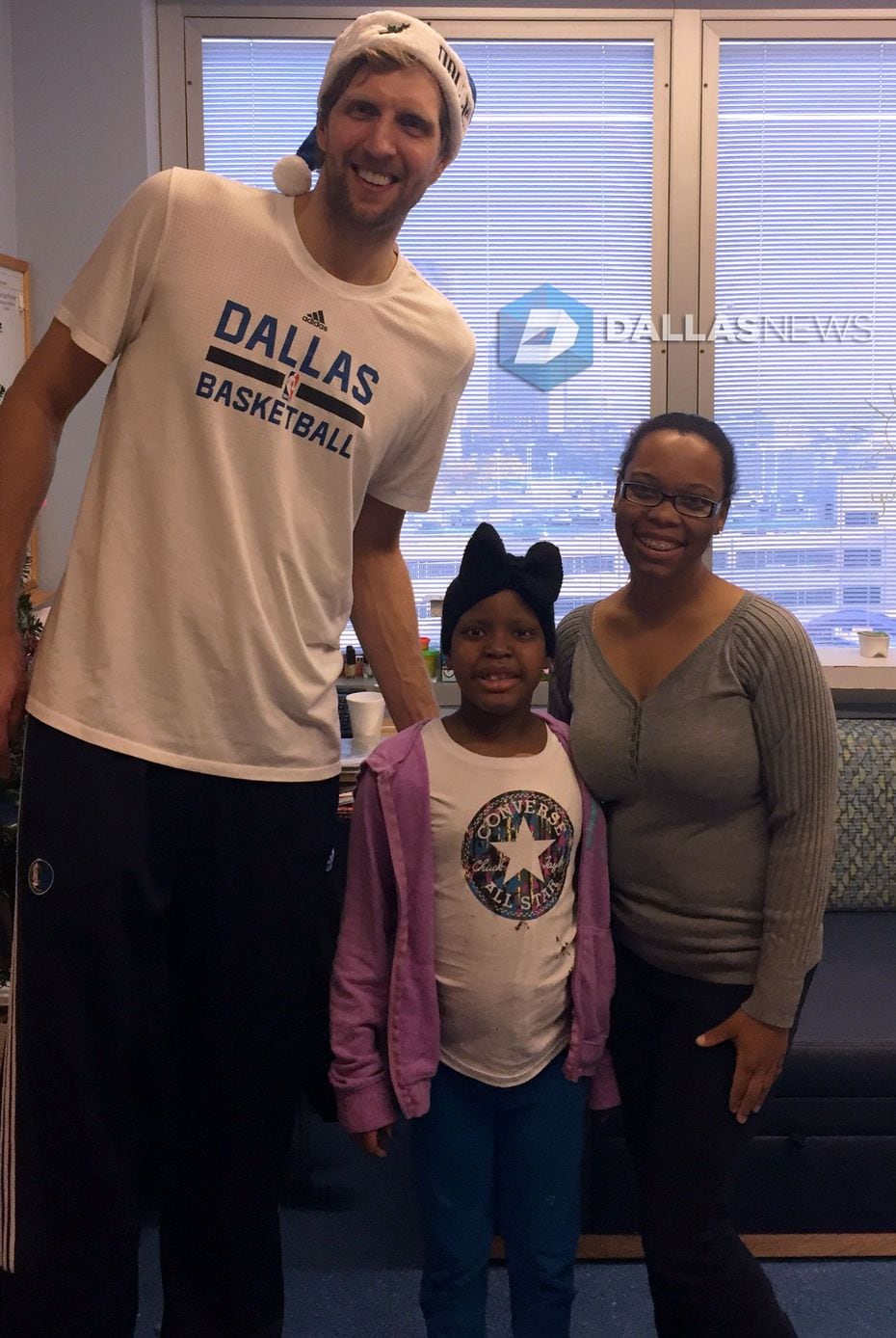 Dirk Nowitzki poses with patient Legecy Allen, 7, and her mother, Roseland Allen, at...