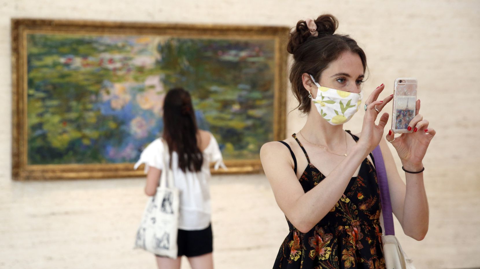 Libby Krueger of Fort Worth takes a photo of paintings in the Kimbell Art Museum as her friend Kimberly Brubacher of Los Angeles views Claude Monet's Water-Lily Pond (1917-19) in Fort Worth, July 14, 2020. 