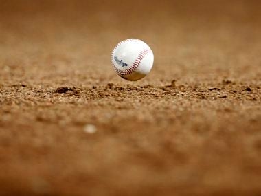 A foul ball bounces in front of the Texas Rangers dugout during a game against the Houston Astros at Globe Life Park in Arlington.