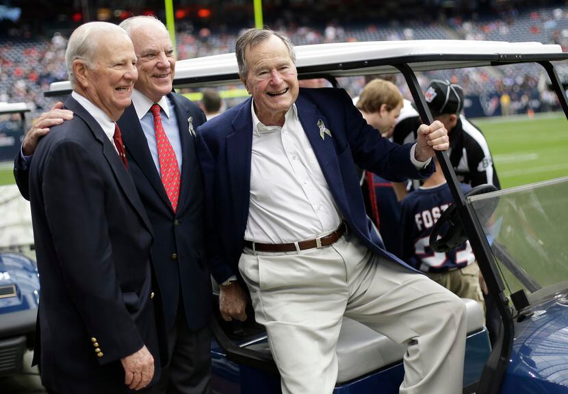 Former President George H.W. Bush (right) shown in a 2012 sideline appearance at a Houston...