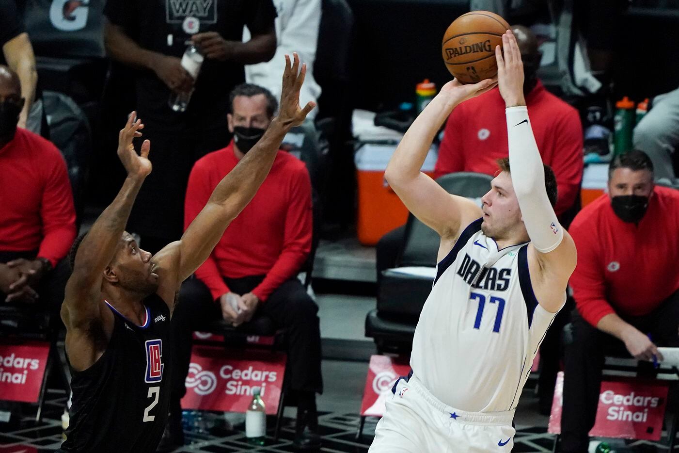Dallas Mavericks guard Luka Doncic (77) shoots a 3-pointer over LA Clippers forward Kawhi Leonard (2) during the second half of an NBA playoff basketball game at Staples Center on Tuesday, May 25, 2021, in Los Angeles.