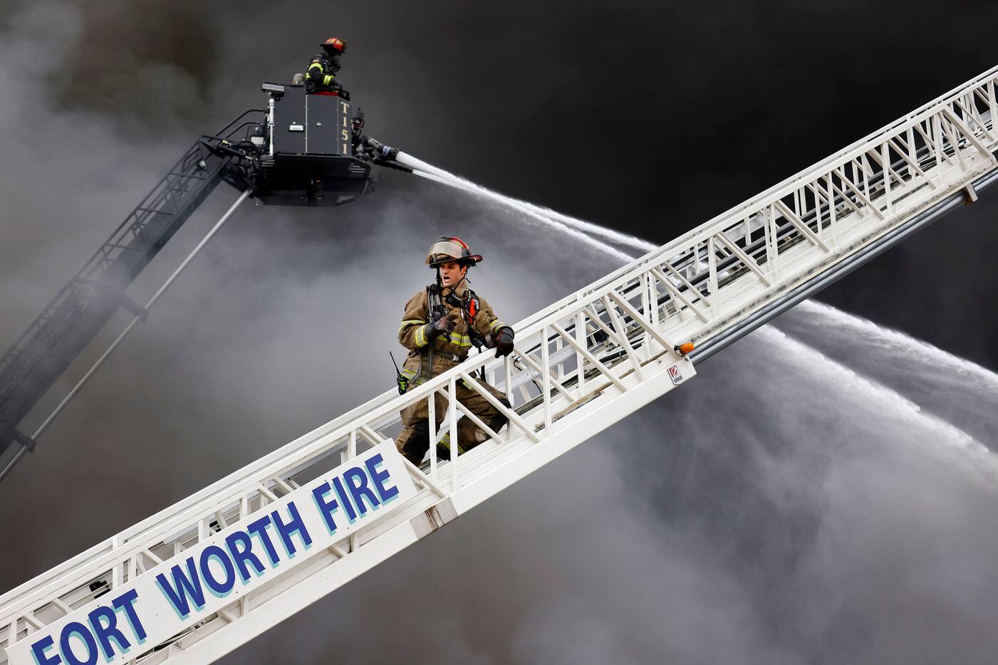 Fort Worth Fire Department Captain Jacob Henderson yells instruction to his crew as they and...