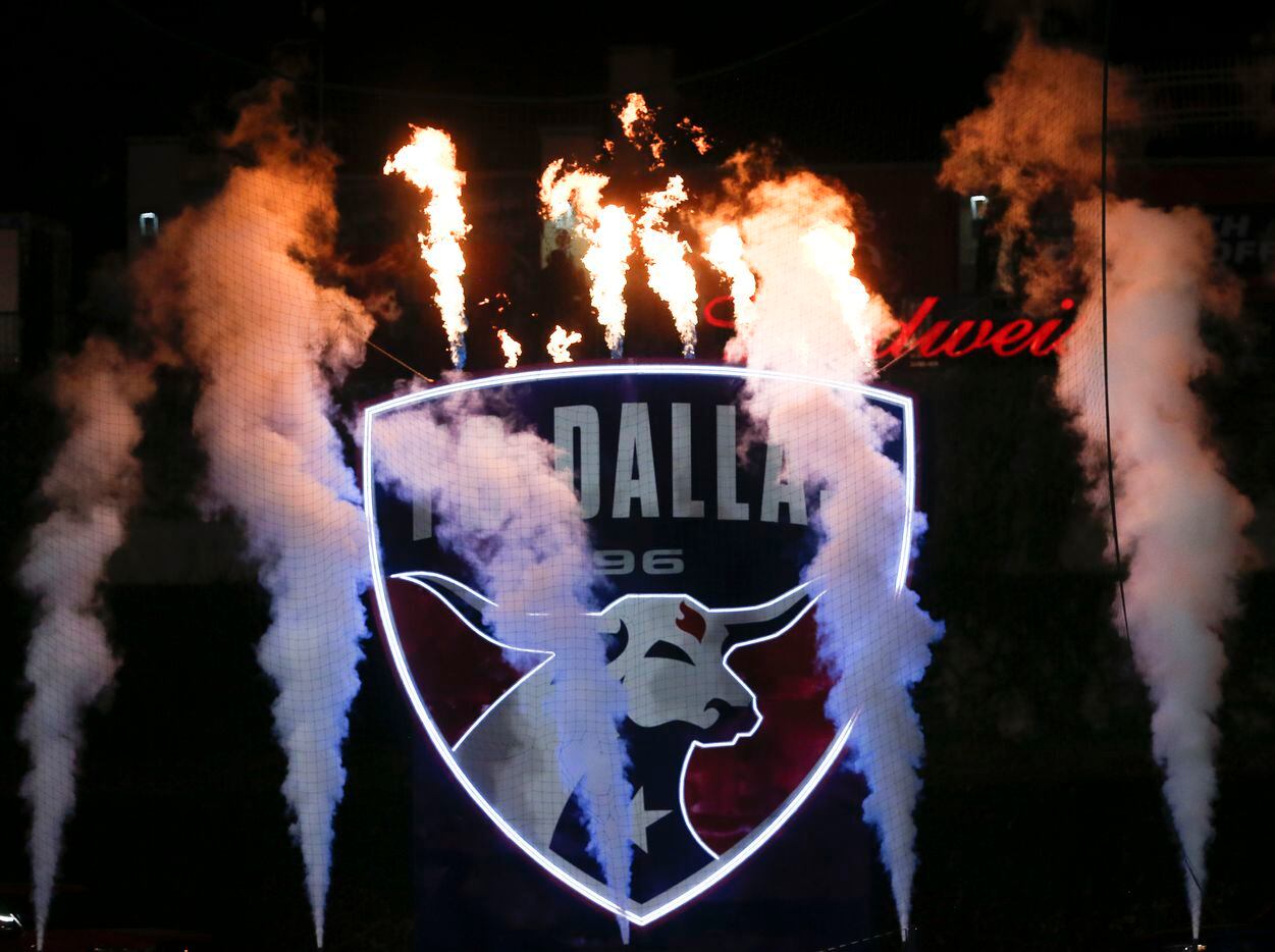 The FC Dallas logo lights up, surrounded by flames and fog, after the team secured a 1-0...